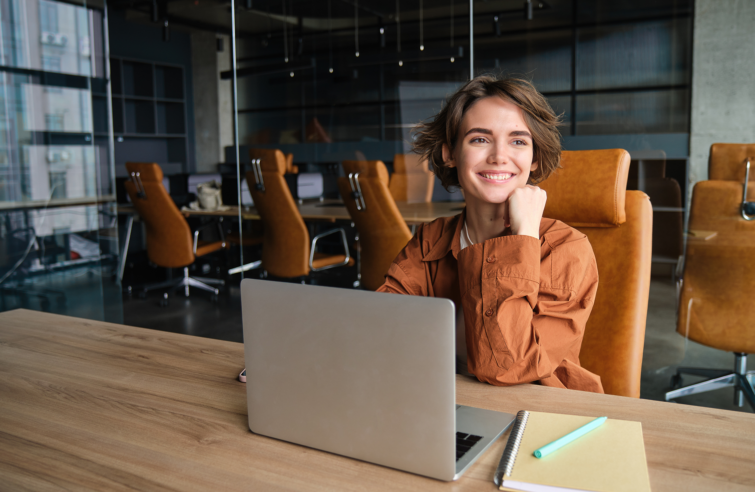 mujer joven sentada trabajando en una laptop